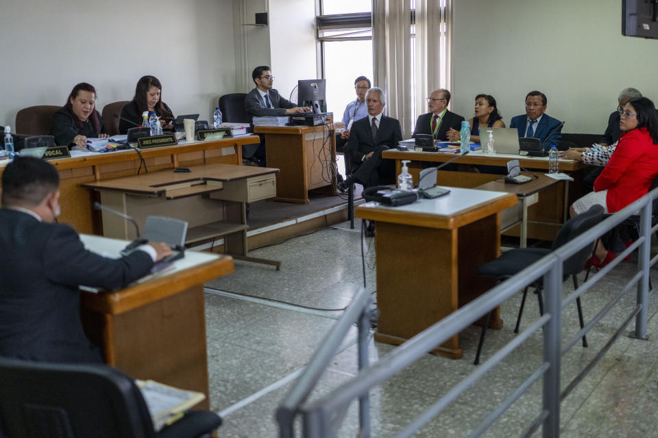 Guatemalan journalist Jose Ruben Zamora, founder of El Periodico newspaper, top center, sits in court in handcuffs for his hearing in Guatemala City, Wednesday, May 15, 2024. Zamora has been jailed for almost two years and seeks his release. (AP Photo/Moises Castillo)