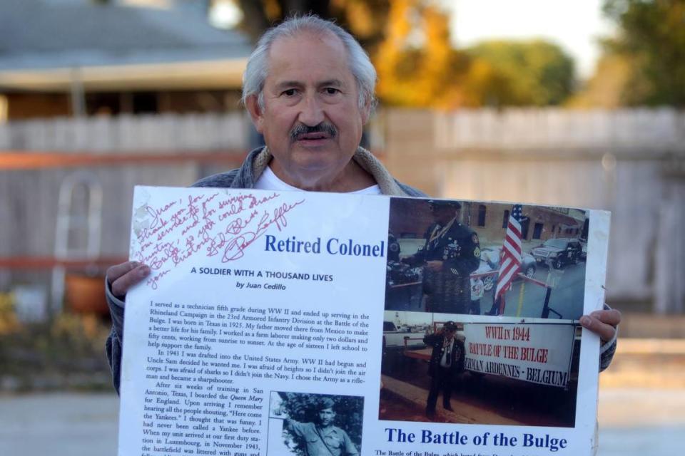 Henry Cedillo sostiene un cartel en honor a su padre, el veterano de la Segunda Guerra Mundial Juan Cedillo. Homenajeará a su padre, fallecido en 2015, participando en el desfile del Día de los Veteranos en Fresno.