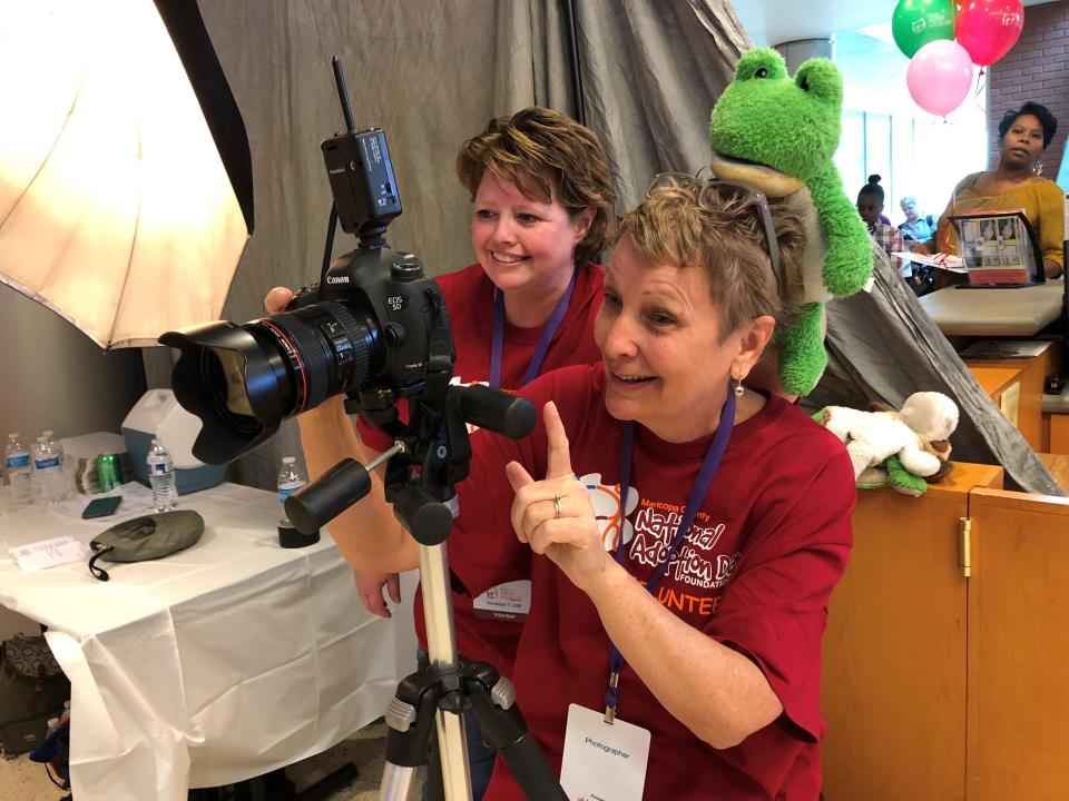 Assistant Sam Kaufman plops a stuffed frog on top of photographer Patty Kaufman's head to make the kids laugh while she took family portraits for Maricopa County's National Adoption Day on Nov. 17, 2018.