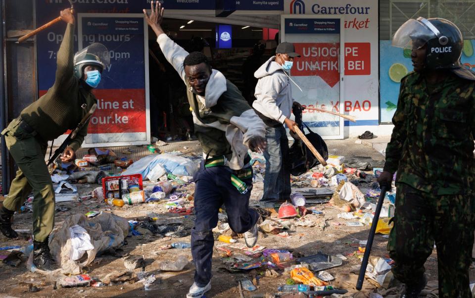 Demonstrator tries to escape from baton blows of a policeman during a protest against government's proposed tax increases