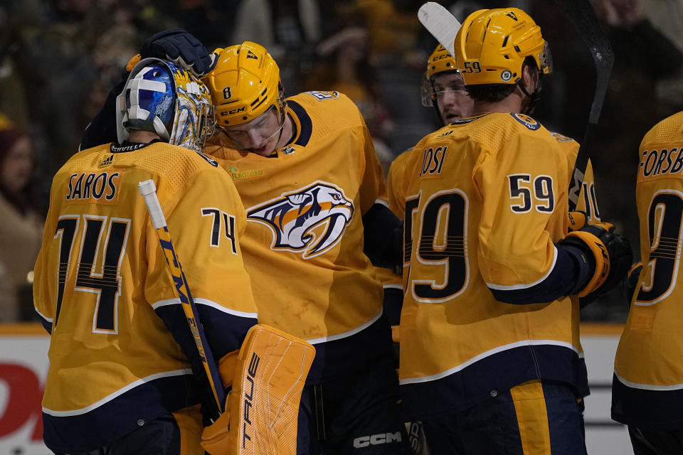 Nashville Predators forward Cody Glass (8) congratulates goaltender Juuse Saros, left, after the team's 5-1 win against the Carolina Hurricanes after a preseason NHL hockey game Thursday, Oct. 5, 2023, in Nashville, Tenn. (AP Photo/George Walker IV)