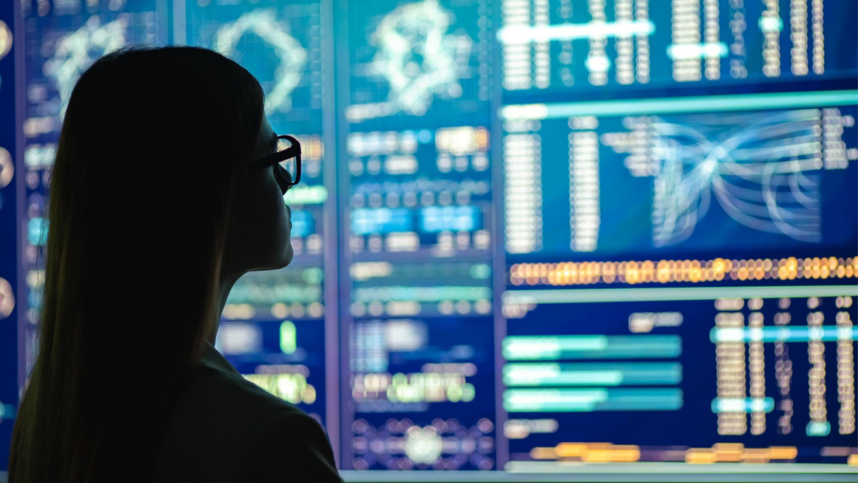 The businesswoman in glasses standing near the display