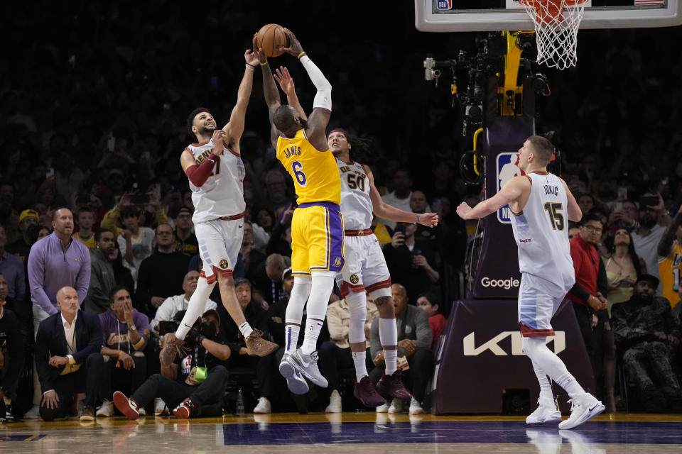 Los Angeles Lakers forward LeBron James (6) misses a layup attempt between Denver Nuggets forward Aaron Gordon (50) and guard Jamal Murray, left, as time expired in the second half of Game 4 of the NBA basketball Western Conference Final series Monday, May 22, 2023, in Los Angeles. Denver won 113-111 to win the series. (AP Photo/Ashley Landis)