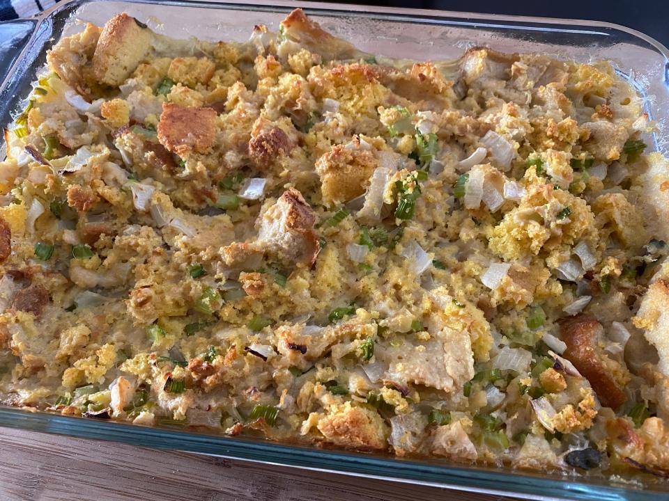 Paula Deen's stuffing cooked in glass baking dish on wooden cutting board