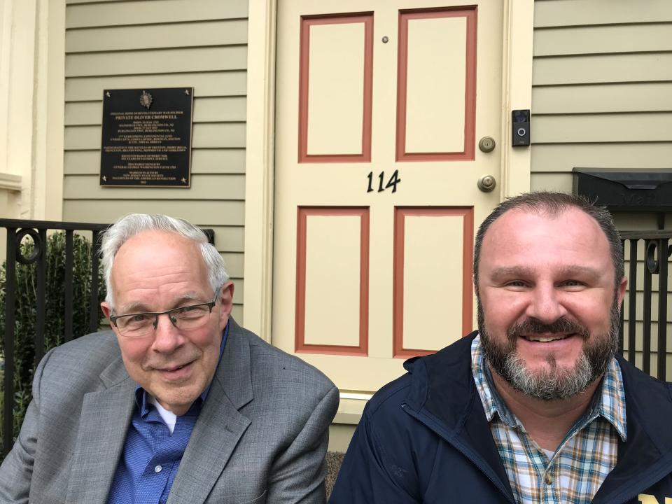 Harry Heck, left, and Craig Clark sit on the front step of the historic Oliver Cromwell house where an historic marker to the left of the door was unveiled by the Daughters of the American Revolution to honor it as the home of decorated Revolutionary War soldier Oliver Cromwell. Heck bought and restored the house and Clark is the tenant and a military veteran.