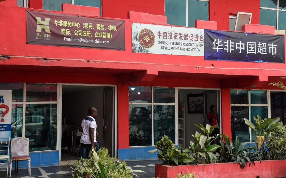 A man walks past empty shops in the deserted China Commercial City shopping centre, popularly called "China Town", in Ojota in Lagos, as people fear of contracting the COVID-19 - AFP