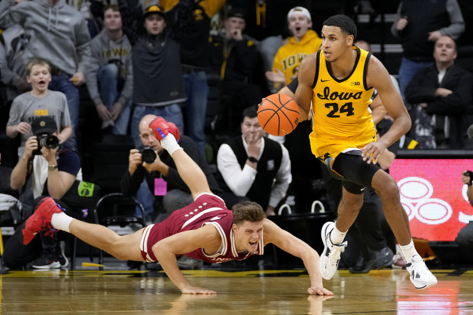 Iowa forward Kris Murray (24) drives up court past Indiana forward Miller Kopp, left, during the second half of an NCAA college basketball game, Thursday, Jan. 5, 2023, in Iowa City, Iowa. Iowa won 91-89. (AP Photo/Charlie Neibergall)