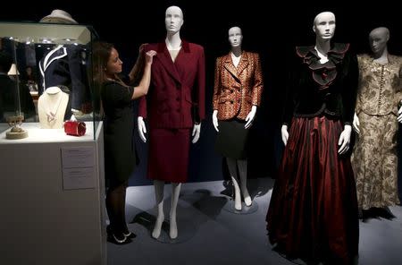 An employee arranges a burgundy wool tweed suit, part of the collection of former British prime minister Margaret Thatcher during an auction preview at Christie's in London, Britain, December 11, 2015. REUTERS/Peter Nicholls