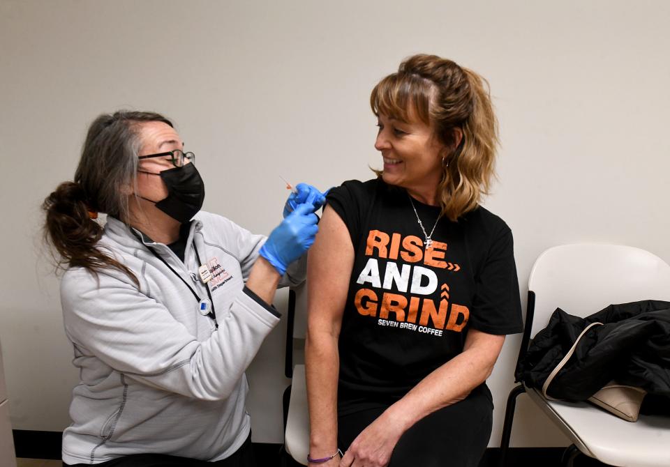 Christin Gogerty, RN, gives Heather Vignos of Massillon a flu shot at Massillon Health Department in Massillon, Ohio Thursday, Dec. 7, 2023. Susan Dubb, public health nurse for the Uncas Health District, encourages those who have not yet received their annual flu shot to do so.