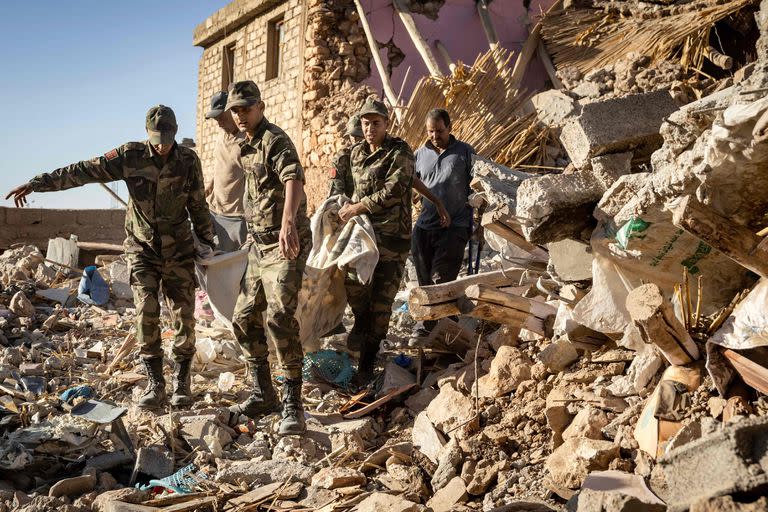 Personal militar traslada un cuerpo en el pueblo de Tafeghaghte, devastado por el terremoto. (FADEL SENNA / AFP)