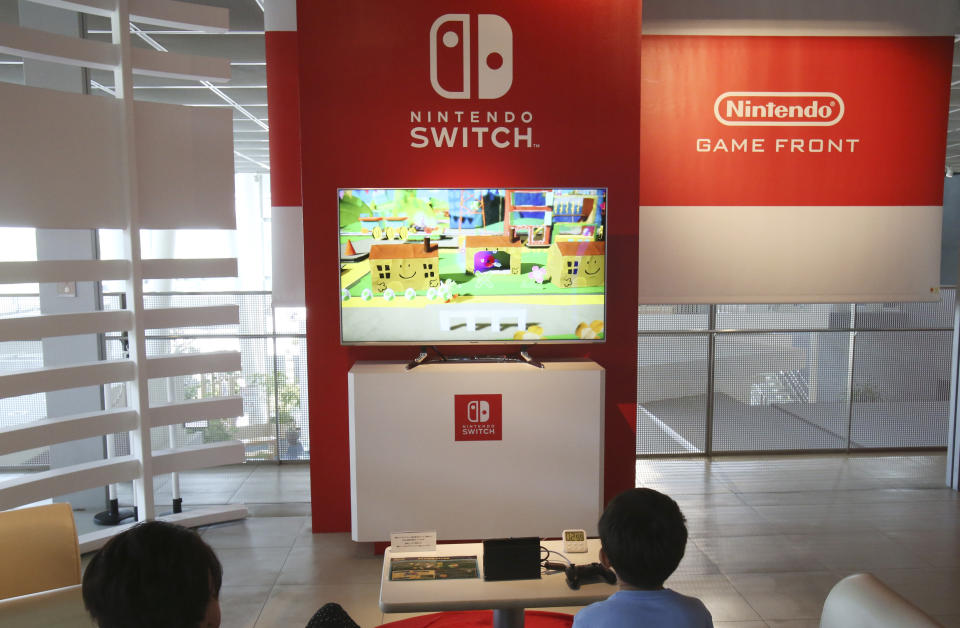 Visitors play a Nintendo Switch game at a showroom in Tokyo, Tuesday, July 30, 2019. Japanese video game maker Nintendo Co. has reported fiscal first quarter profit dipped to about half of what it was the previous year despite improved sales as an unfavorable exchange rate eroded earnings. (AP Photo/Koji Sasahara)