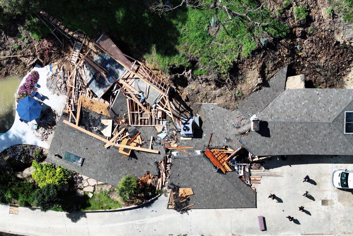 An aerial view of people walking near a landslide that destroyed two homes and damaged another residence in the Sherman Oaks neighborhood on March 13, 2024 in Los Angeles, California.