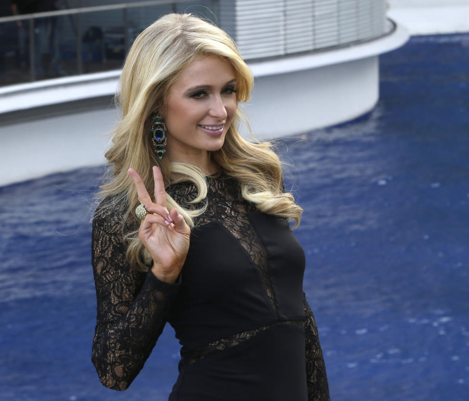 Paris Hilton gestures after unveiling the Paris Beach Club, which she designed in collaboration with Philippine developer Century Properties, Thursday, March 13, 2014, in Paranaque city, southeast of Manila, Philippines. The bean-shaped, three-story club fronting a man-made beach is within the resort-themed Azure condominium community. Hilton unveiled her first real estate project Thursday in metropolitan Manila and said she wants to follow in the footsteps of her great-grandfather and grandfather, who led a luxury hotel empire. (AP Photo/Bullit Marquez)