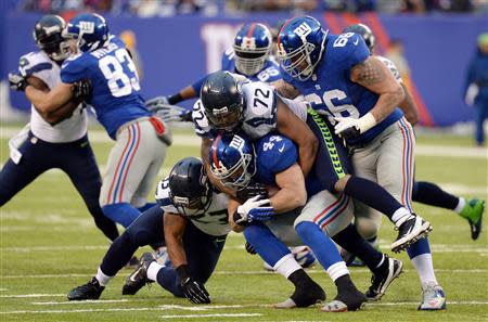 Dec 15, 2013; East Rutherford, NJ, USA; Seattle Seahawks defensive end Michael Bennett (72) tackles New York Giants running back Peyton Hillis (44) during the second half at MetLife Stadium. Mandatory Credit: Joe Camporeale-USA TODAY Sports