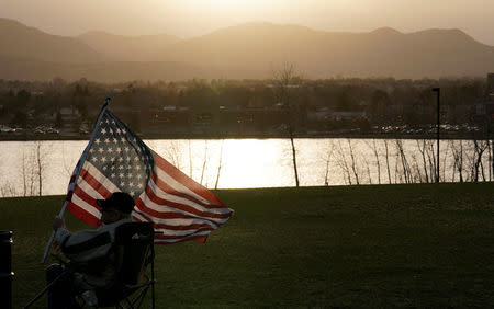 A man holds a flag as teens kick off a voter registration rally, a day ahead of the 19th anniversary of the massacre at Columbine High School, in Littleton, Colorado, U.S., April 19, 2018. REUTERS/Rick Wilking