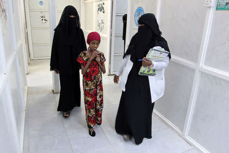 Saida Ahmad Baghili, 18, who has been affected by severe malnutrition, walks with a nurse and a relative at the al-Thawra hospital in the Red Sea port city of Hodeidah, Yemen November 26, 2016. REUTERS/Abduljabbar Zeyad