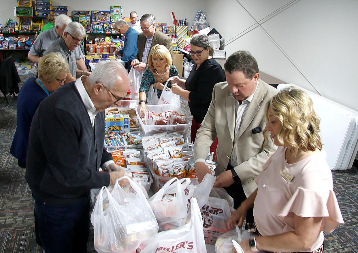 Dave Kowalka, left, and other members of Ashland Rotary pack food bags for children at Associated Charities as a part of their service project at the Ashland Rotary Club meeting on Tuesday, May 3, 2022.