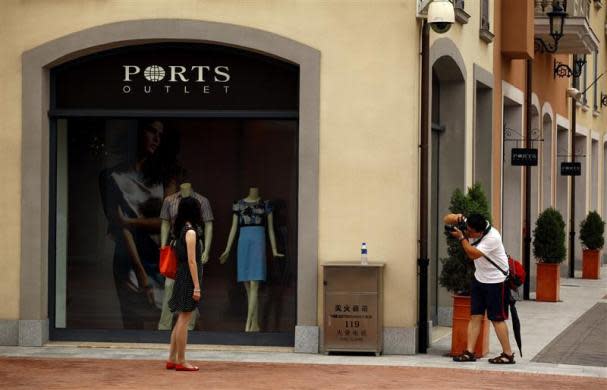 A man takes a photograph of a woman outside a fashion store in the Florentia Village in the district of Wuqing, located on the outskirts of the city of Tianjin June 13, 2012. <br><br><a href="http://news.yahoo.com/photos/china-replicates-austrian-village-slideshow/" data-ylk="slk:Click here;elm:context_link;itc:0;sec:content-canvas;outcm:mb_qualified_link;_E:mb_qualified_link;ct:story;" class="link  yahoo-link">Click here</a> to see a related gallery: China replicates Austrian village