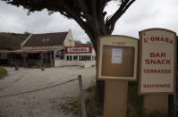 In this photo taken on Thursday, June 4, 2020, a sign reads 'annual closure' on a restaurant at Omaha Beach in Saint-Laurent-sur-Mer, Normandy, France. In sharp contrast to the 75th anniversary of D-Day, this year's 76th will be one of the loneliest remembrances ever, as the coronavirus pandemic is keeping nearly everyone from traveling. (AP Photo/Virginia Mayo)