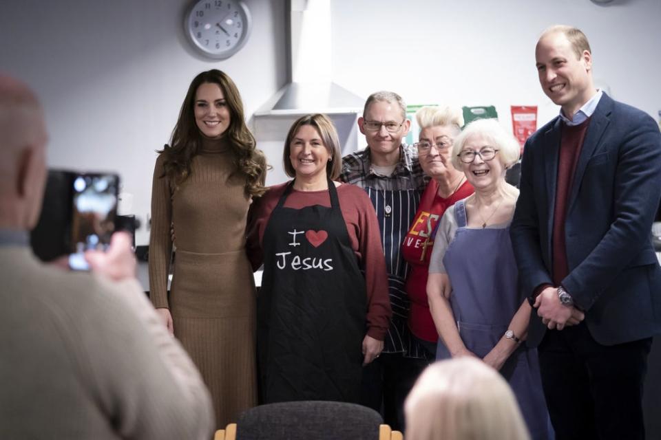 The Duke and Duchess of Cambridge stop for a photograph with volunteers and staff (PA)