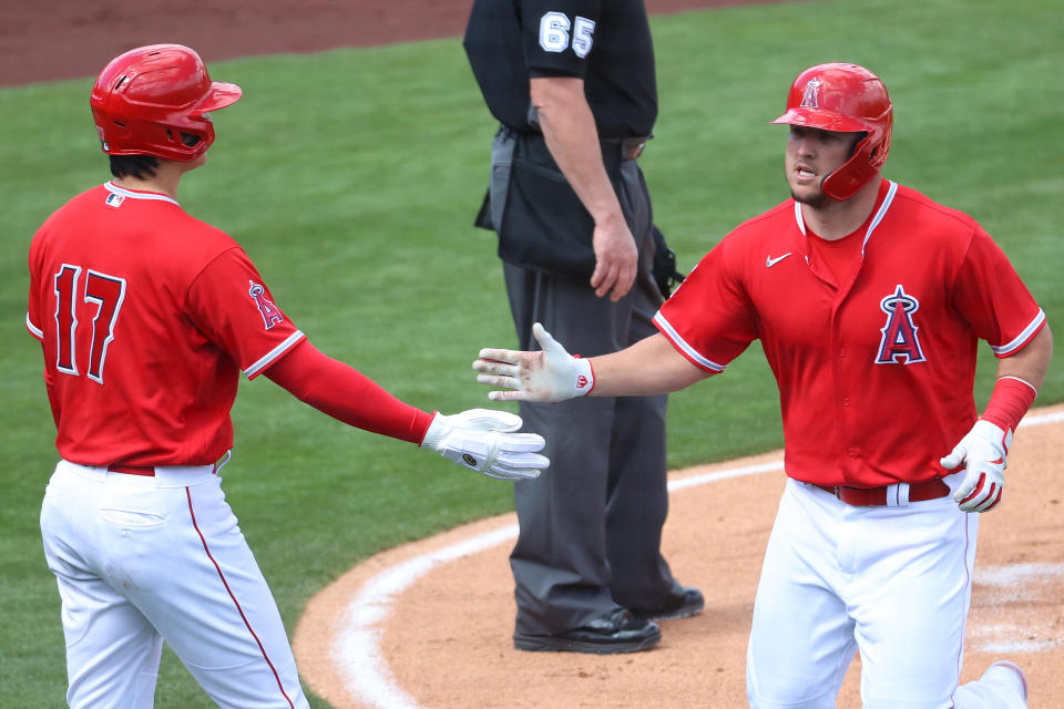 TEMPE, ARIZONA - MARCH 16: Shohei Ohtani #17 and Mike Trout #27 of the Los Angeles Angels high five after scoring off an error by Amed Rosario #1 of the Cleveland Indians in the first inning during the MLB spring training baseball game at Tempe Diablo Stadium on March 16, 2021 in Tempe, Arizona. (Photo by Abbie Parr/Getty Images)