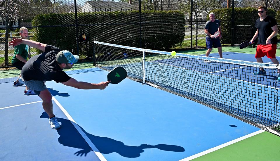 With the temperature Thursday perfect for outdoor activity, Christian Powers, reaching for the ball, and partner Matthew Patrick compete in pickleball against Joe Calo and Matt Cunha. The contest is at Ellsworth McAfee Park in Northborough.