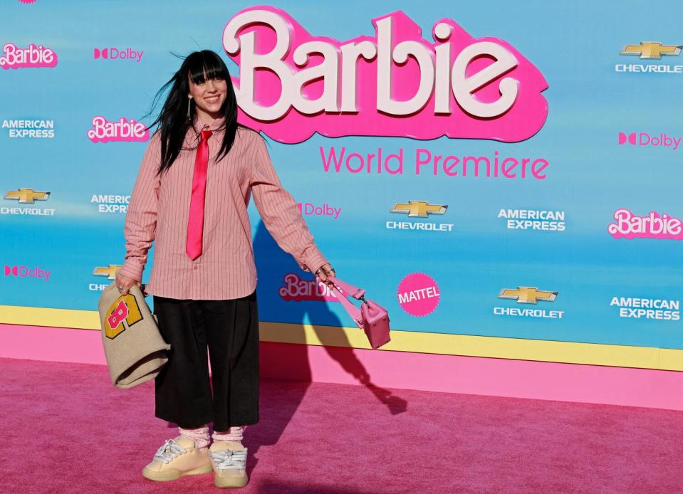 A female singer in a pink shirt arrives at a movie premiere