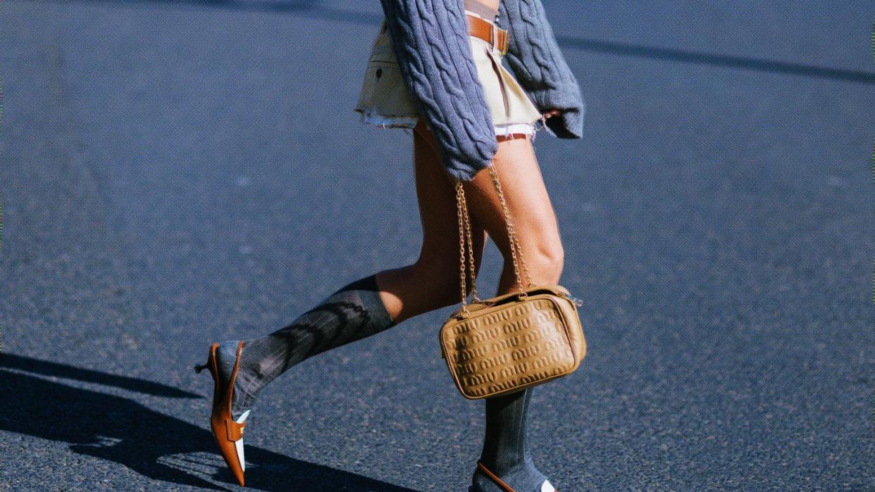 paris, france   march 08 caroline daur poses wearing a miu miu cropped grey sweater, a miu miu cropped shirt, miu miu mini skirt and miu miu light brown leather bag after the miu miu show at the palais de iena during paris fashion week   womenswear fw 2022 2023 on march 08, 2022 in paris, france photo by vanni bassettigetty images