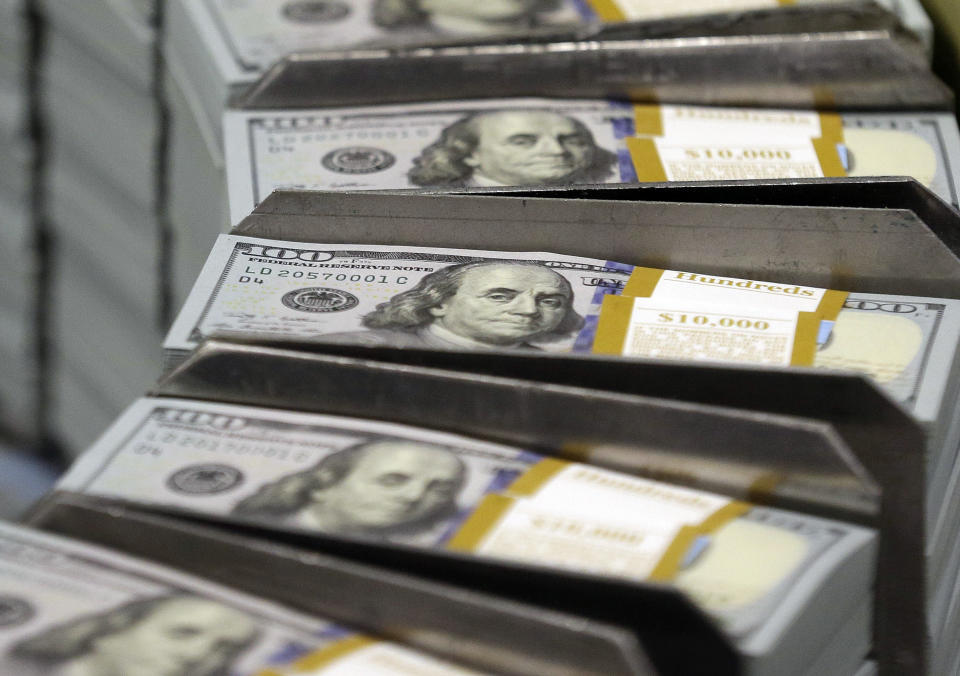 FILE - Cut stacks of $100 bills make their way down the line at the Bureau of Engraving and Printing Western Currency Facility in Fort Worth, Texas, Sept. 24, 2013. All the hand-wringing over a potential government default if Congress doesn’t increase the national debt limit has conjured up images of past government shutdowns. In fact, there’s a big difference between a government default and a government shutdown. A default would occur if the government exceeds its legal borrowing limit and can no longer pay all its creditors or pay for existing programs. (AP Photo/LM Otero, File)