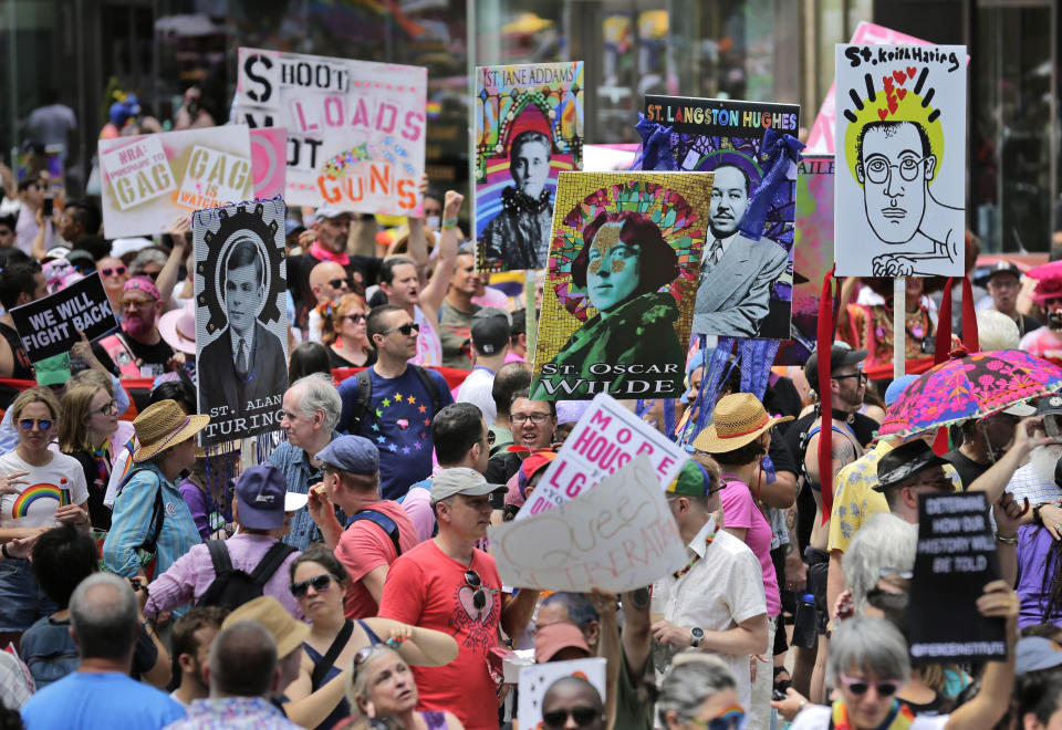 FILE - In this June 30, 2019, file photo, marchers carry signs with historical LGBTQ figures during the Queer Liberation March in New York. This year's Pride events were supposed to be a blowout as LGBTQ people the world over marked the 50th anniversary of the first parade to celebrate what were then the initial small steps in their ability to live openly, and to advocate for bigger victories. Now, Pride is largely taking a backseat, having been driven to the internet by the coronavirus pandemic and now by calls for racial equality that were renewed by the killing of George Floyd in Minneapolis at the hands of police. (AP Photo/Seth Wenig, File)