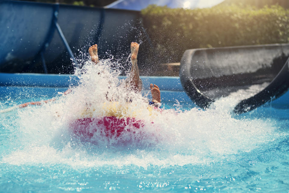 Two people on a tube riding down a waterslide