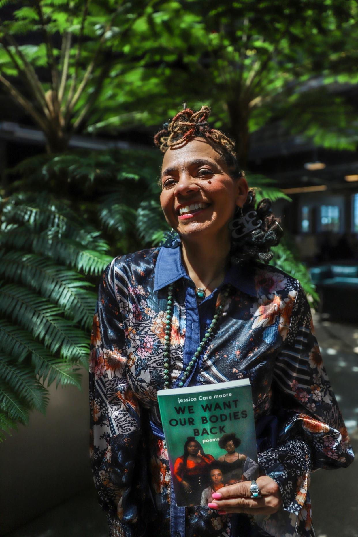 Jessica Care Moore was announced as the new poet laureate of Detroit at Newlab in Detroit on Tuesday, April 30, 2024. She holds a copy of her latest book, "We Want Our Bodies Back."