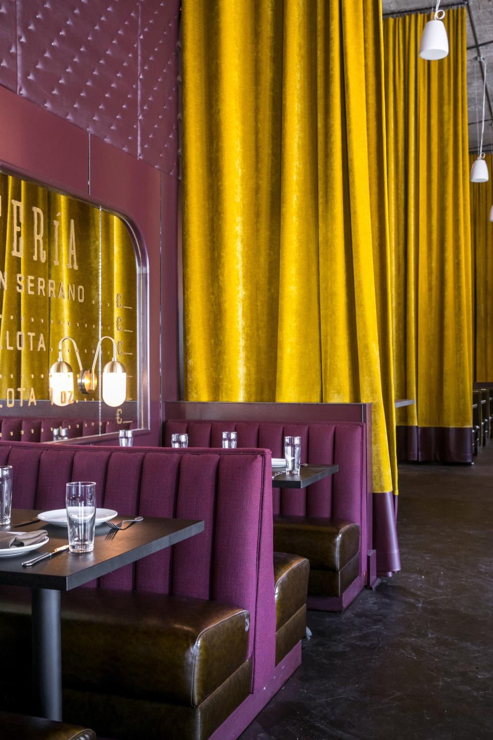 Tall mustard-colored curtains bridge the gap between the top and bottom levels of the restaurant.