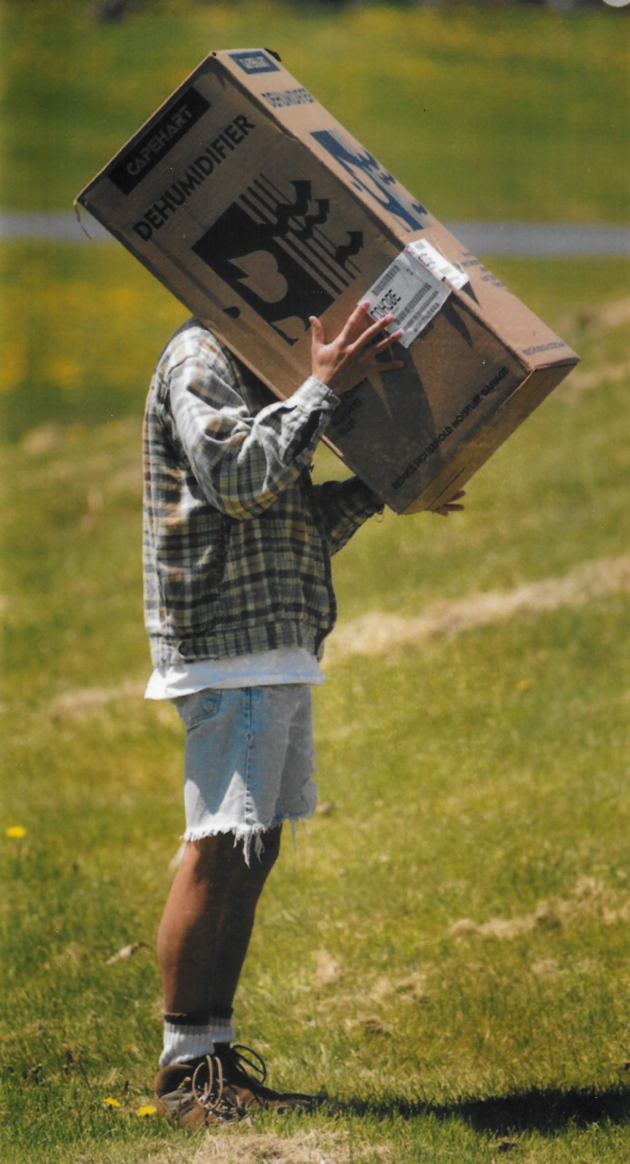 Niles resident Rob Ting, a medical student at the University of Toledo, puts his head in a cardboard box to view a pinhole projection of the solar eclipse May 10, 1994, over Wauseon, Ohio.