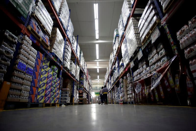 FILE PHOTO: Costumers walk in the corridors of a beverage depot at the wholesale market "Central de Abastos" in Mexico City