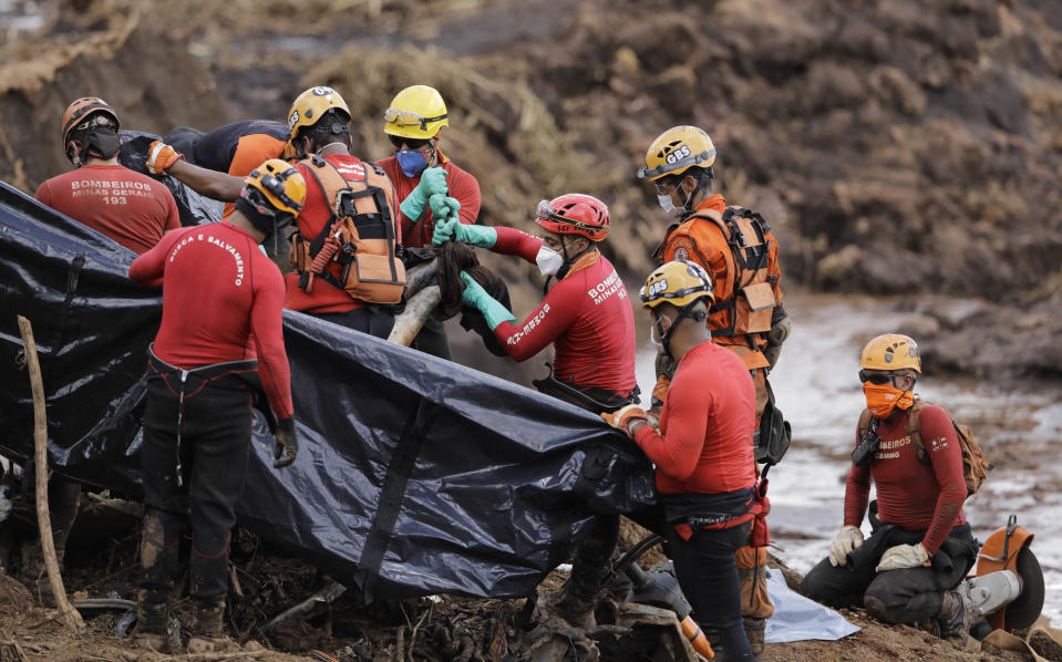 Firefighters pull a body from the mud days after a dam collapse in Brumadinho, Brazil, Monday, Jan. 28, 2019. Firefighters on Monday carefully moved over treacherous mud, sometimes walking, sometimes crawling, in search of survivors or bodies four days after a dam collapse that buried mine buildings and surrounding neighborhoods with iron ore waste. (AP Photo/Leo Correa)