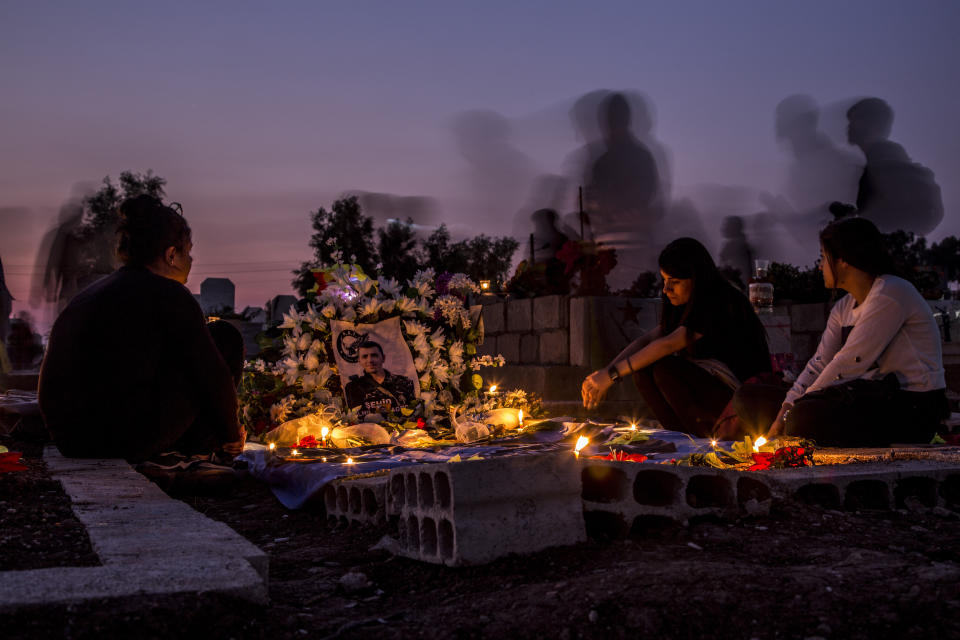 Relatives visit a grave of Syrian Democratic Forces fighter recently killed during Turkish offensive, in the town of Qamishli, north Syria, Thursday, Oct. 31, 2019. (AP Photo/Baderkhan Ahmad)