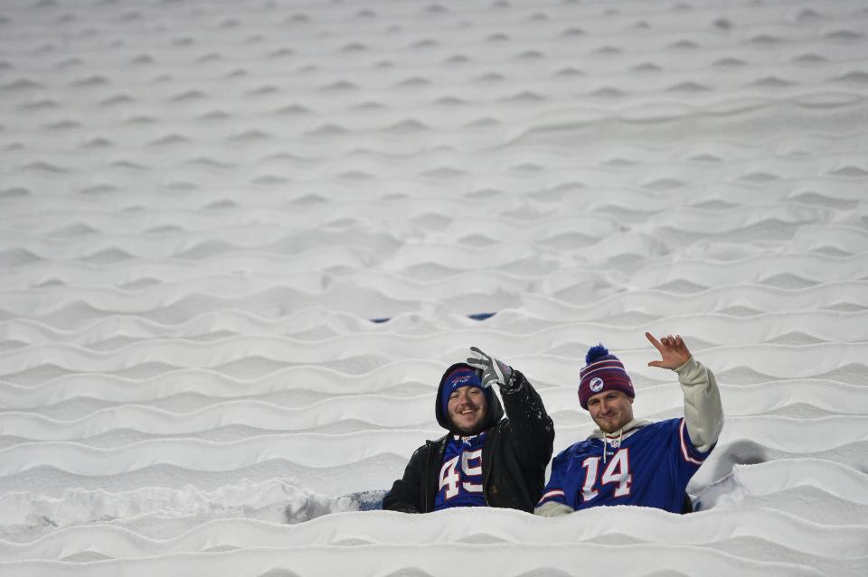 Buffalo Bills fans sit in snow-covered seats during warmups before an NFL football game between the Buffalo Bills and the Miami Dolphins in Orchard Park, New York, Saturday, Dec. 17, 2022.