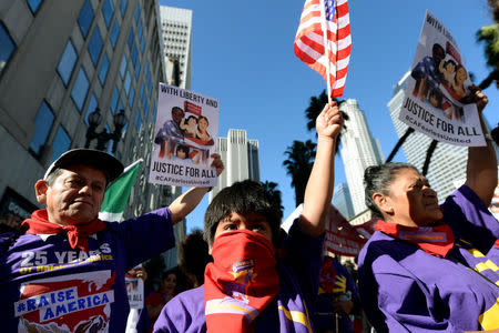 Protesters hold up signs during a march and rally against the United States President-elect Donald Trump in Los Angeles, California, U.S., December 18, 2016.REUTERS/Kevork Djansezian