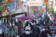 People wearing protective masks to help curb the spread of the coronavirus stroll along a shopping street in Tokyo Thursday, Jan. 14, 2021. The Japanese capital confirmed more than 1500 new coronavirus cases on Thursday. (AP Photo/Eugene Hoshiko)