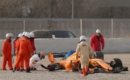 F1 Formula One - Formula One Test Session - Circuit de Barcelona-Catalunya, Montmelo, Spain - February 26, 2018. Fernando Alonso of McLaren inspects his car after losing a rear tyre during testing. Picture taken February 26, 2018. REUTERS/Albert Gea