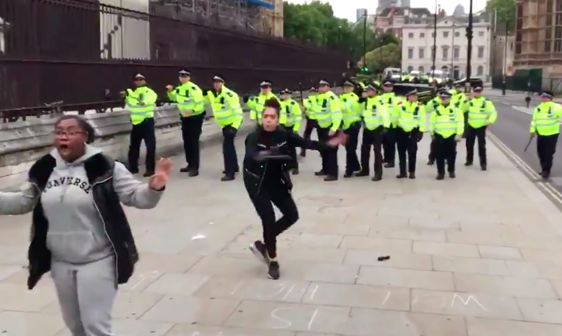 Two women stood between retreating police and protesters in central London on Sunday (Matthew Thompson/Twitter)