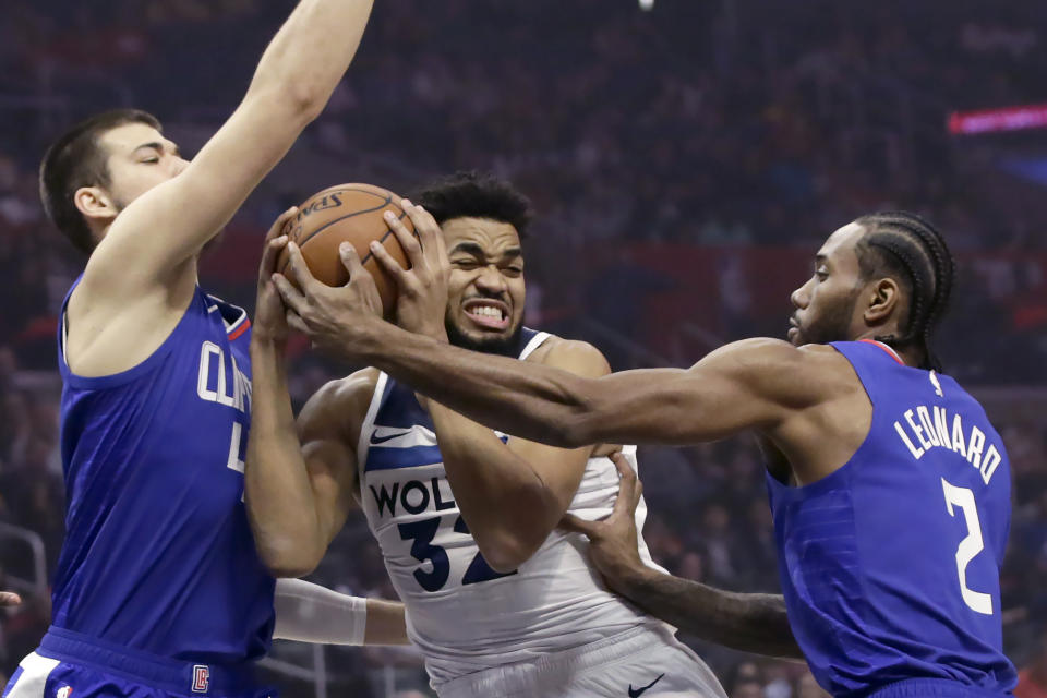 Minnesota Timberwolves center Karl-Anthony Towns (32) collides with Los Angeles Clippers center Ivica Zubac (40) with forward Kawhi Leonard (2) defending during the first half of an NBA basketball game in Los Angeles, Saturday, Feb. 1, 2020. (AP Photo/Alex Gallardo)