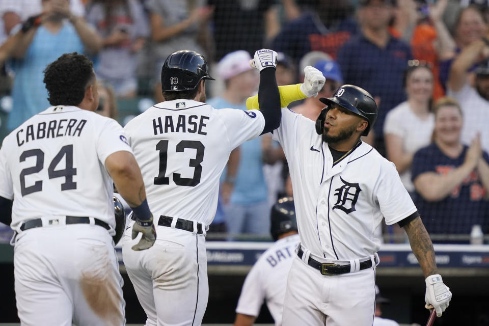 Detroit Tigers' Eric Haase, center, is greeted by Harold Castro, right, after the two-run home run that also scored Miguel Cabrera during the fourth inning of a baseball game against the Cleveland Guardians, Tuesday, July 5, 2022, in Detroit. (AP Photo/Carlos Osorio)