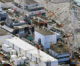FILE - This Sept. 4, 2017, aerial file photo shows Fukushima Dai-ichi nuclear power plant's reactors, from bottom at right, Unit 1, Unit 2 and Unit 3, in Okuma, Fukushima prefecture, northeastern Japan. Japan revised a roadmap on Friday, Dec. 27, 2019, for the tsunami-wrecked Fukushima nuclear plant cleanup, further delaying the removal of thousands of spent fuel units that remain in cooling pools since the 2011 disaster. It's a key step in the decadeslong process, underscoring high radiation and other risks. (Daisuke Suzuki/Kyodo News via AP, File)/Kyodo News via AP)
