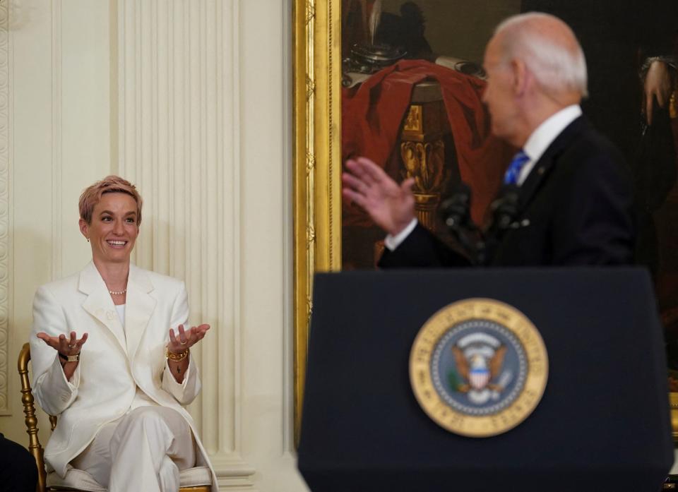 Megan Rapinoe (left) reacts as President Joe Biden references her during the 2022 Presidential Medal of Freedom ceremony.