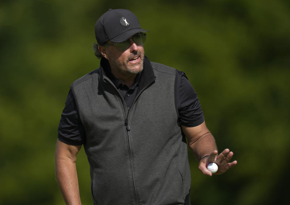 Phil Mickelson of the United States reacts to the crowd after putting on the 15th green during the final round of the inaugural LIV Golf Invitational at the Centurion Club in St Albans, England, Saturday, June 11, 2022. (AP Photo/Alastair Grant)