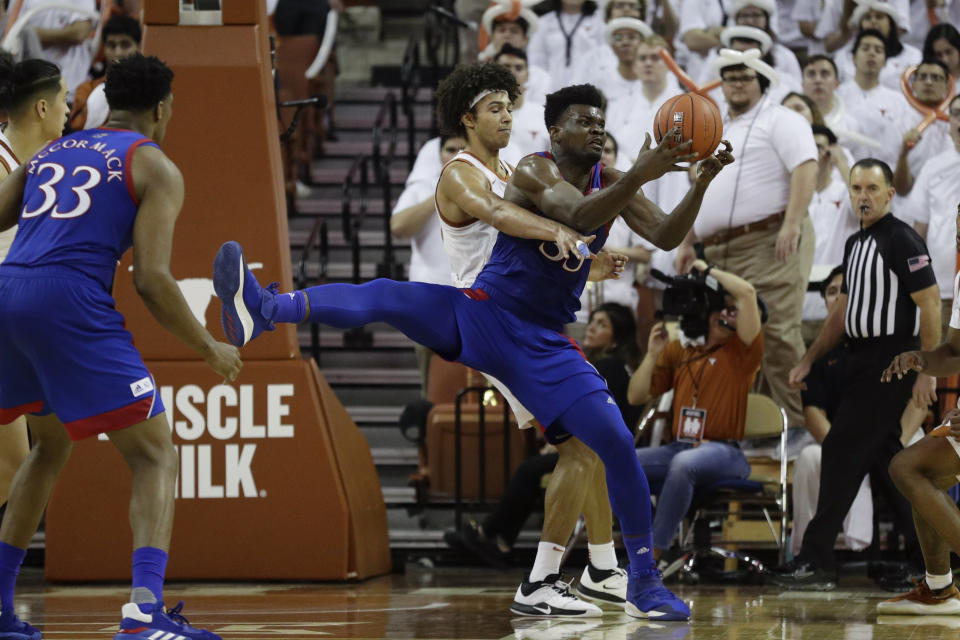 Kansas center Udoka Azubuike (35) is pressured by Texas forward Jericho Sims (20) as he grabs a rebound during the second half of an NCAA college basketball game, Saturday, Jan. 18, 2020, in Austin, Texas. (AP Photo/Eric Gay)