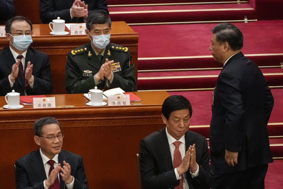 FILE - Then newly elected China's Defense Minister Gen. Li Shangfu, top second left, applauds with delegates as Chinese President Xi Jinping, right, walks to deliver a speech at the closing ceremony during China's National People's Congress (NPC) at the Great Hall of the People in Beijing on March 13, 2023. China has replaced Defense Minister Gen. Li, who has been out of public view for almost two months with little explanation, state media reported Tuesday, Oct. 24. (AP Photo/Andy Wong, File)