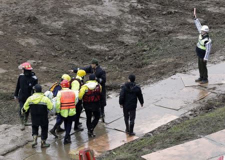 Emergency personnel carry a body of a passenger who died in the TransAsia Airways Flight GE235 plane crash in New Taipei City February 6, 2015. REUTERS/Pichi Chuang